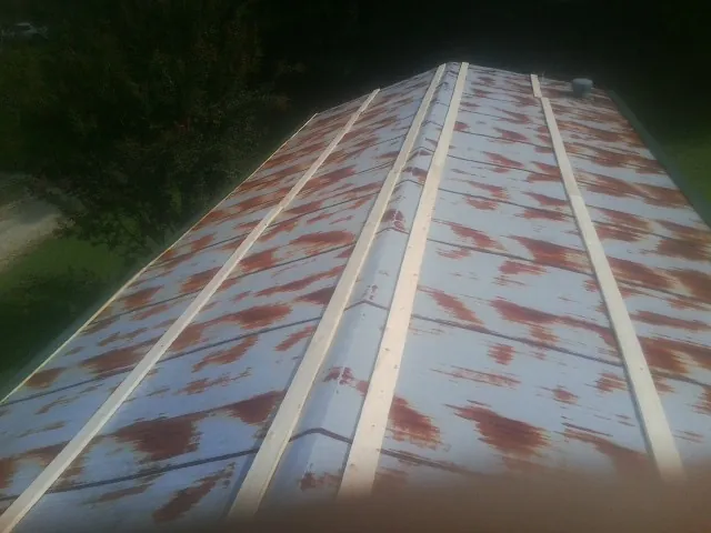 Rusted metal roof panels with new wood purlins before replacement — Storm Damage Roof Repair in Colwell by Roofing Brothers