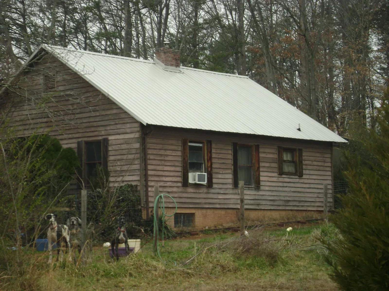 White metal roof on an old wood sided farmhouse, from a Metal Roof Installation job in Colwell